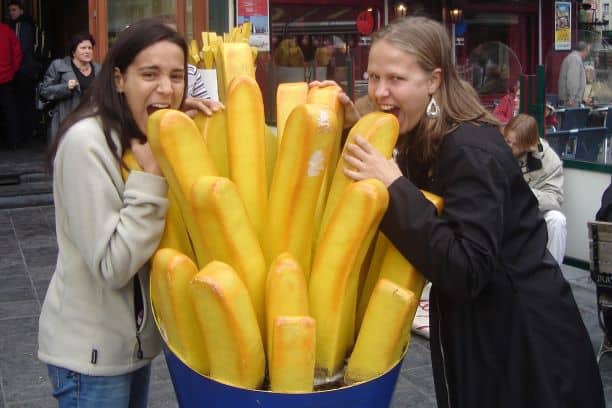 Duas garotas mordendo uma batata frita gigante