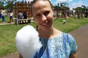 Garota comendo algodão doce no parque cidade das crianças em Holambra